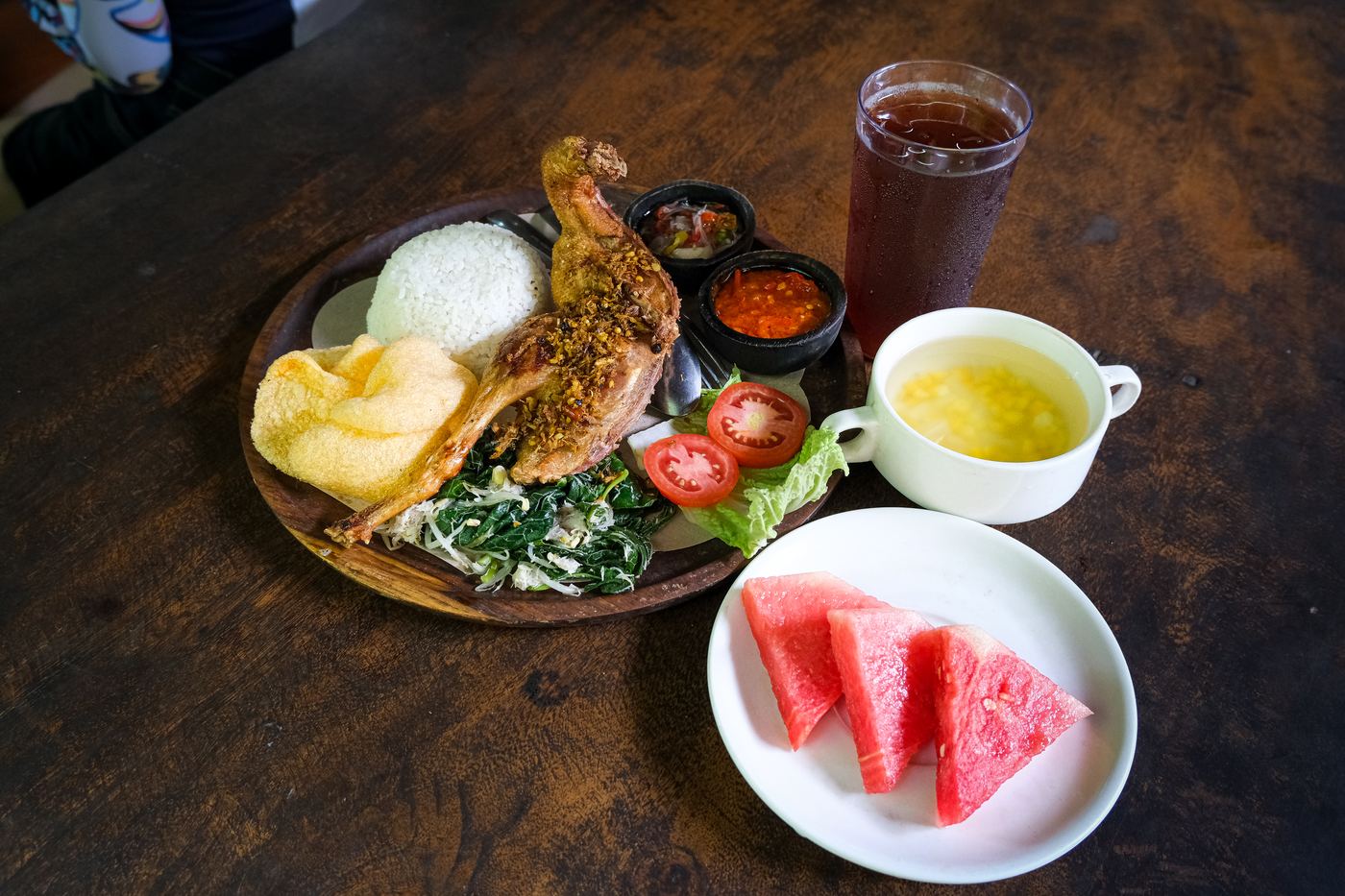 Crispy Balinese fried duck served with rice, sambal, crackers, and fresh fruit